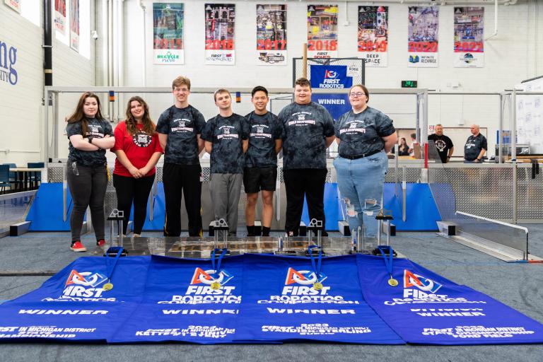 Metal Muscle poses with their trophies and banners at Kettering University's Robotics Community Center.