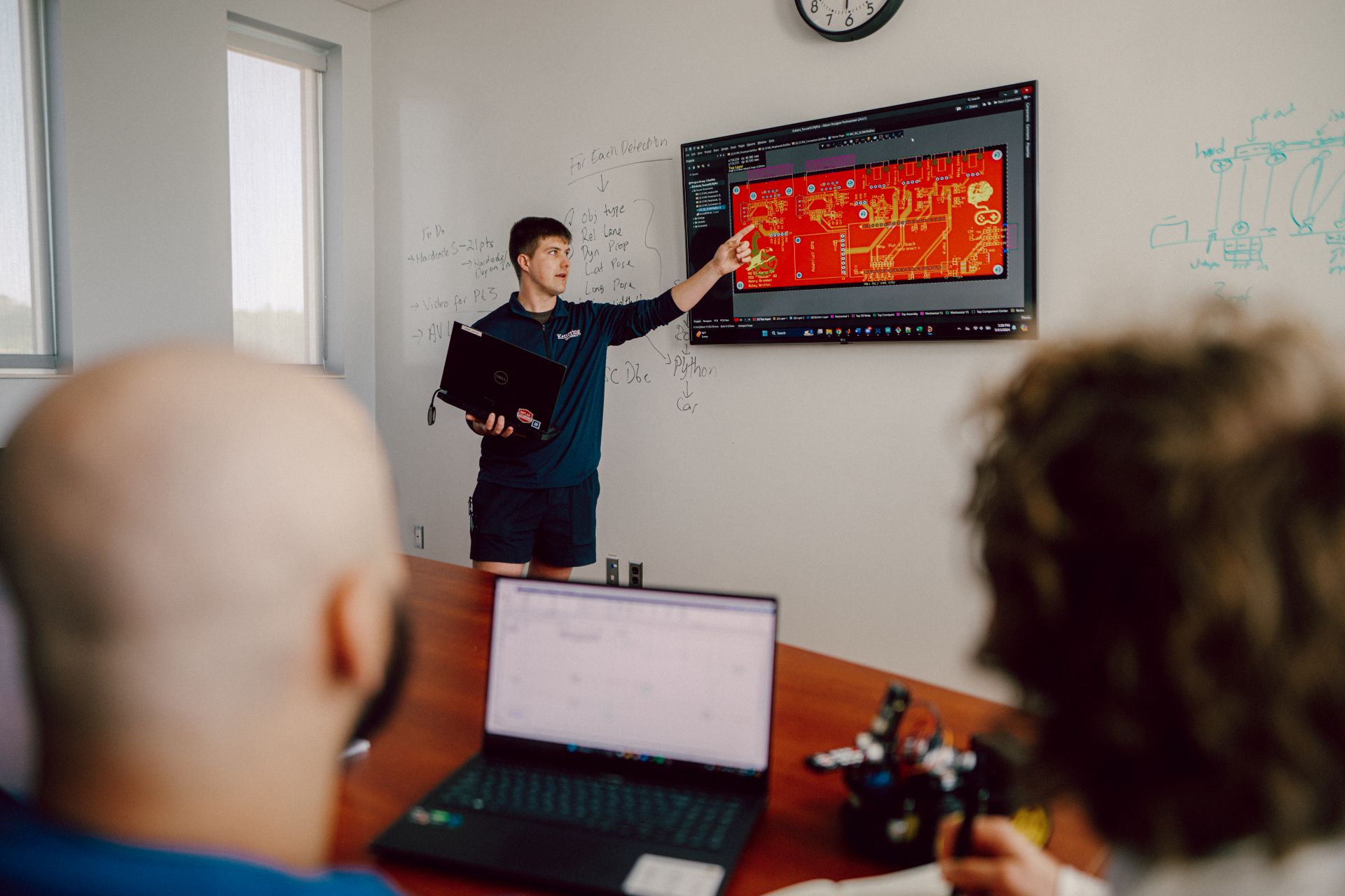 Kettering Electric Vehicle Certificate student presenting a circuit board design on a large digital screen in a classroom