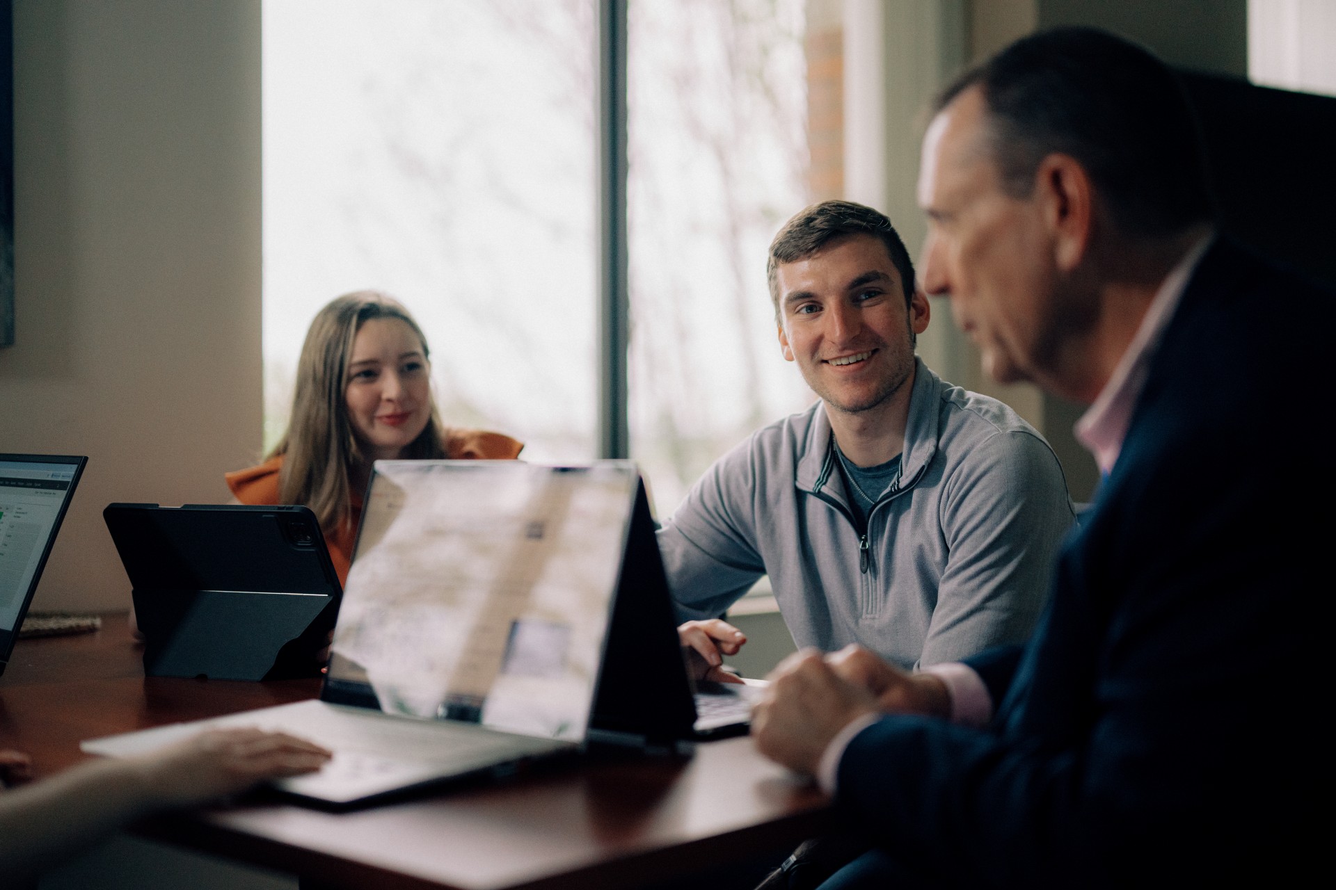 Supply Chain Management master's students working with a professor during a group collaboration session in an academic lounge