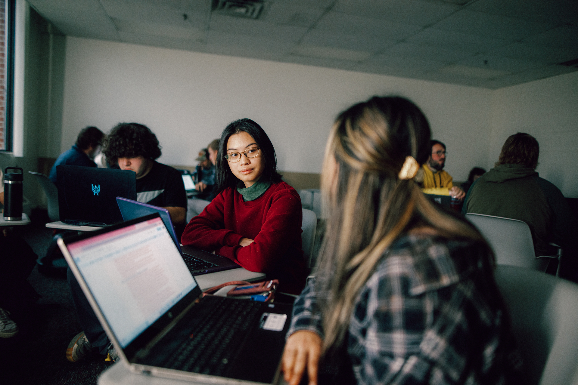 Two Kettering Supply Chain Management Certificate students collaborating seated at laptops in a classroom study session