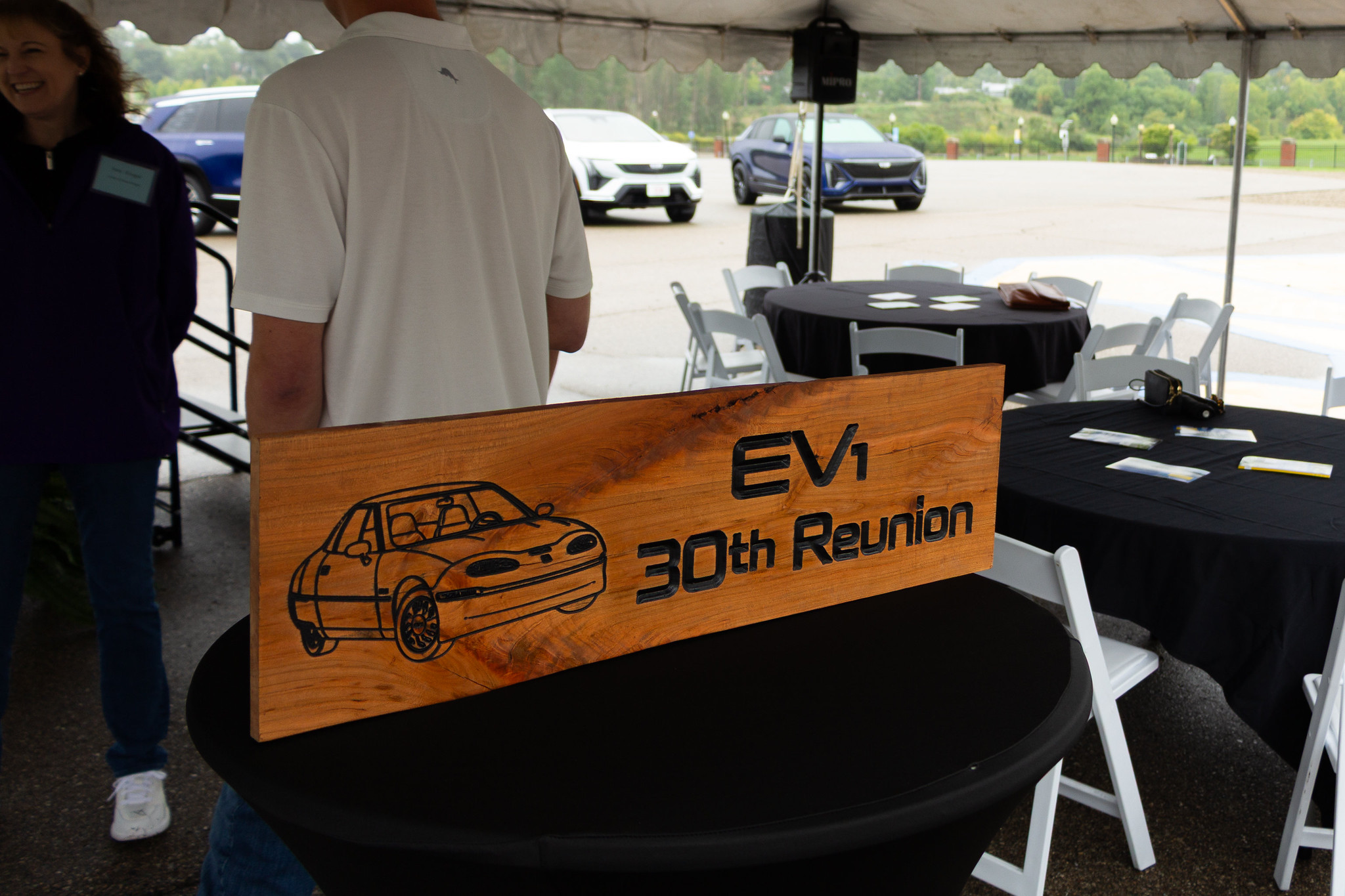 A wood signs with an image of the EV1 and "EV1 30TH Reunion" etched into the surface. 