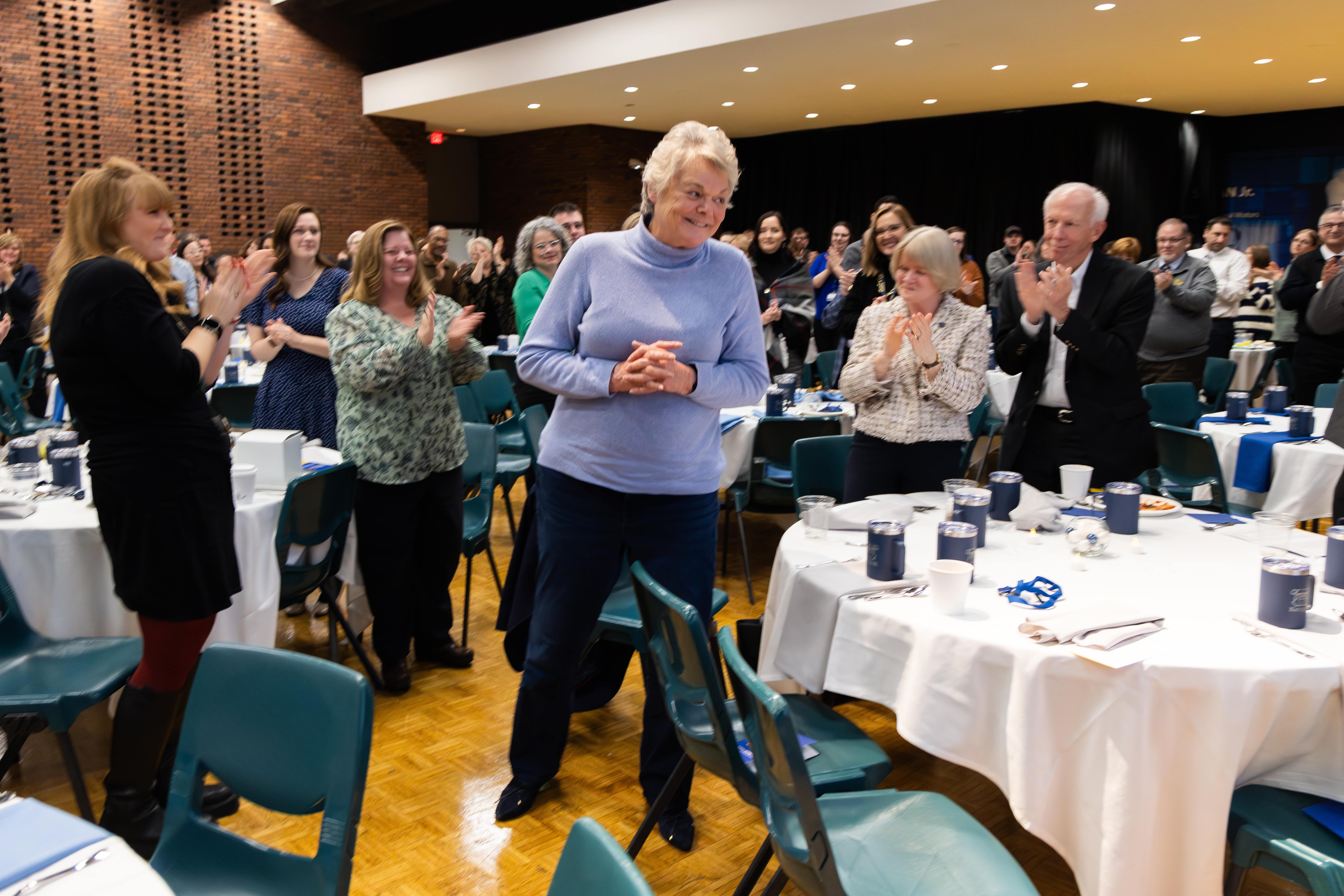 Betsy Homsher stands and thanks her colleagues for their praise at Kettering University's 2023 Celebration of Excellence.