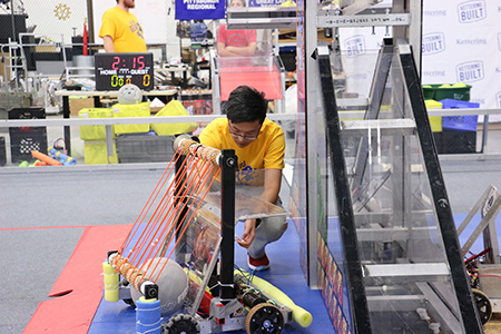 Students from China and Vietnam work on their robotos for the competition