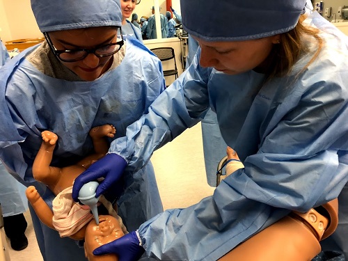 Students participate in an obstetrics simulation workshop.