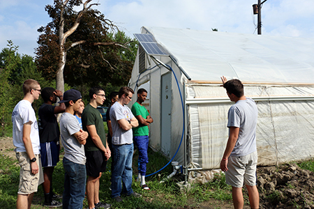 Students show off the hoophouse they are working to make self sustaining