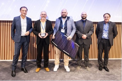 Five men pose for a photo with an award and a small solar panel.