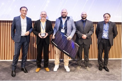 Five men pose for a photo with an award and a small solar panel