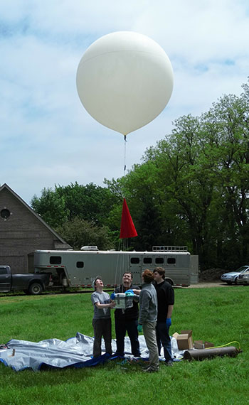 Physics Club members pose with their weather balloon