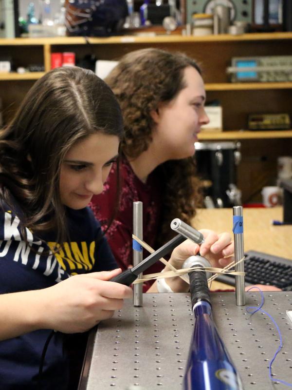 Students take measurements of vibrations on a baseball bat in the acoustics lab.