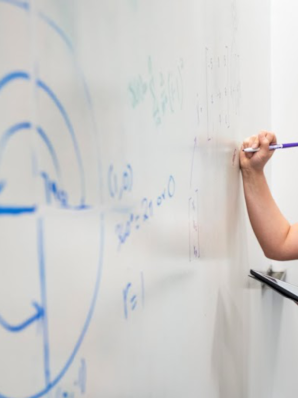 A student works a problem on a whiteboard