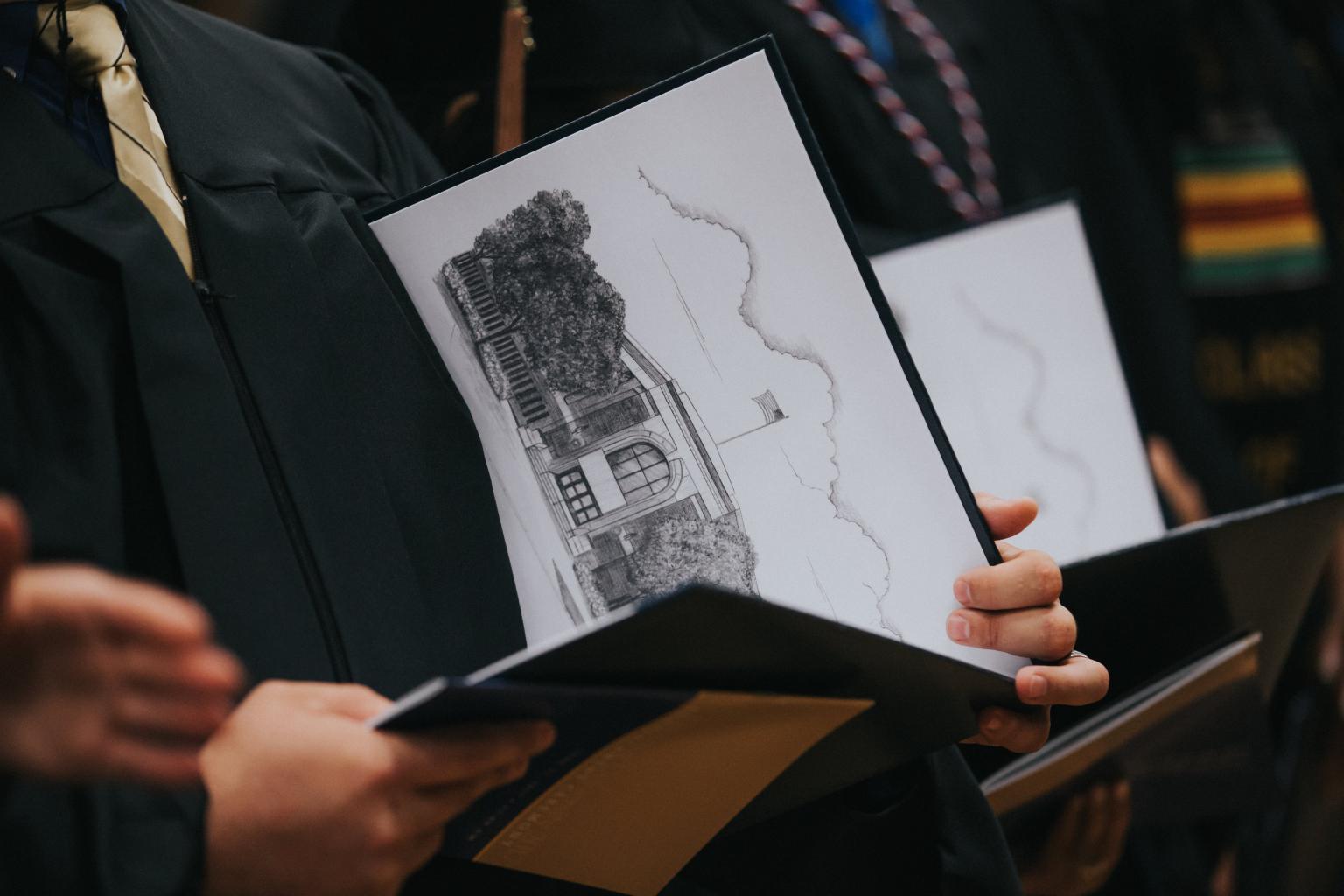 A graduate holding a Kettering University diploma