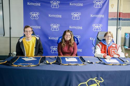 Three students pose with their Esports jerseys and letters at attend Kettering University.