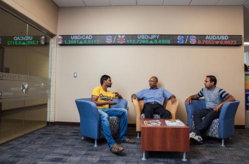 Graduate students discuss latest business trends with a faculty member in the School of Management.