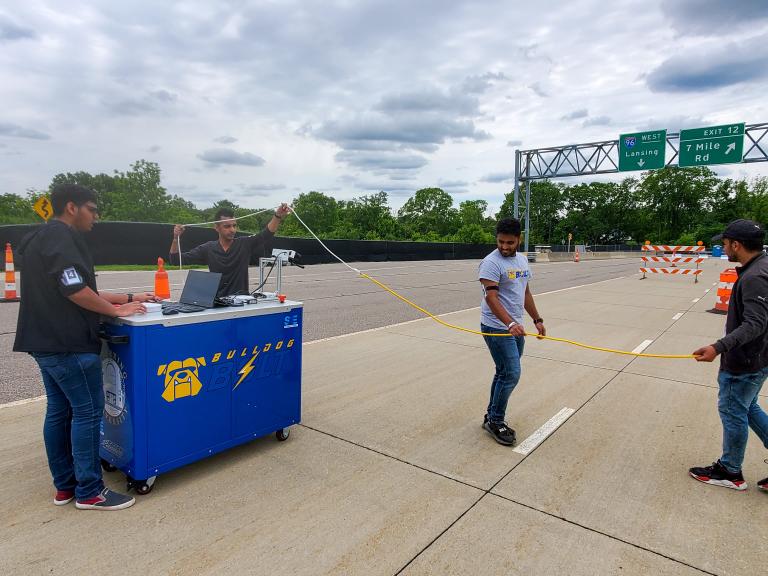 Members of the Kettering University AutoDrive team work with their cart during competition.