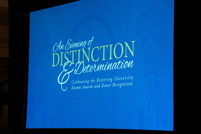 A screen displays "An Evening of Distinction and Determination" slide