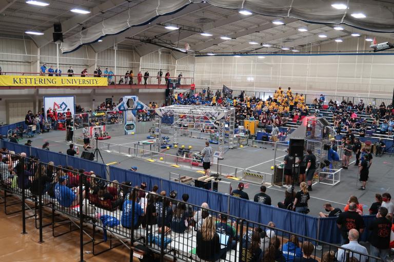 Students, staff and parents watch as robots take the field during the FIRST Robotics Kick-off at Kettering University.