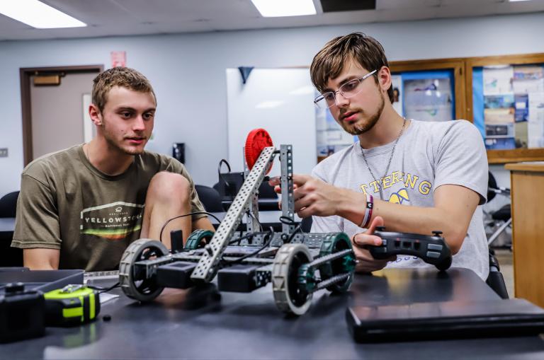 Two Kettering University students work on a robot in an Industrial and Mechanical Engineering class.