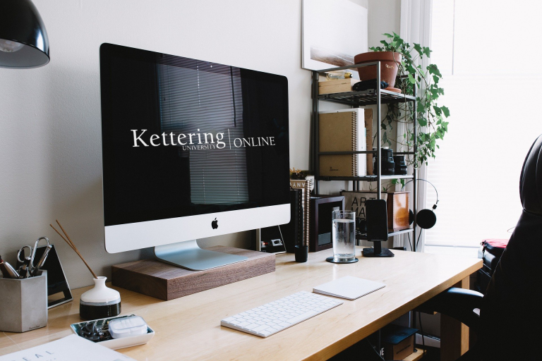An office with a Mac computer on desk with Kettering Online logo on screen.