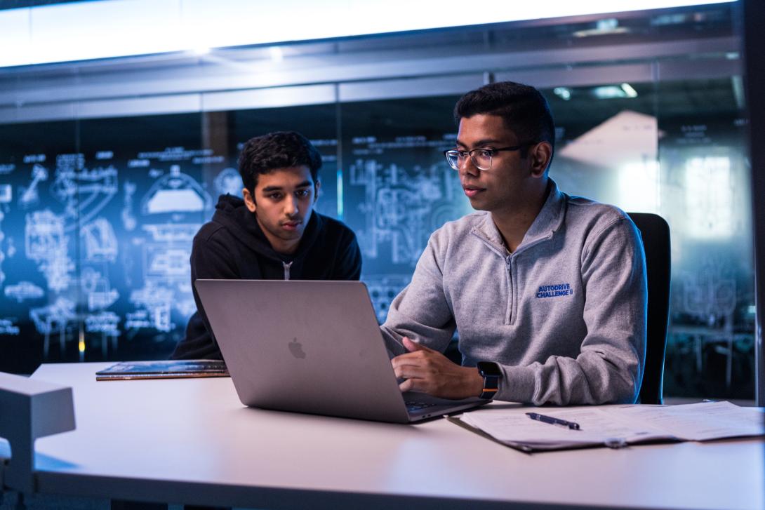 students tudying over computer at desk